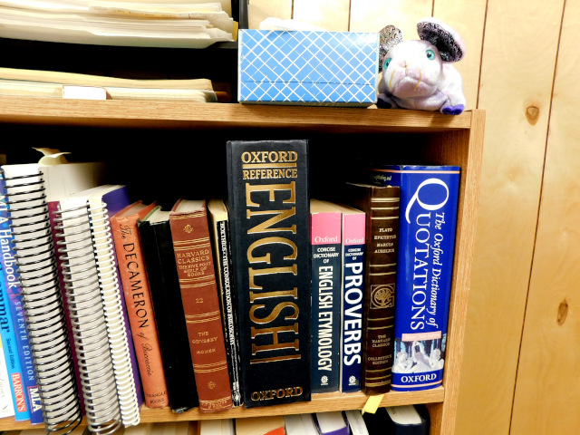 Photo of my book shelf with the English Oxford Dictionary prominently displayed.
The second photo is the opened dictionary with a magnifying glass highlighting "protest."