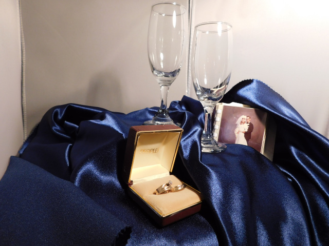 First photo is of a ring box with our wedding bands (my wedding band together with my engagement ring). Second photo includes a tiny wedding picture, two wine glasses and the ring box with our wedding rings.
